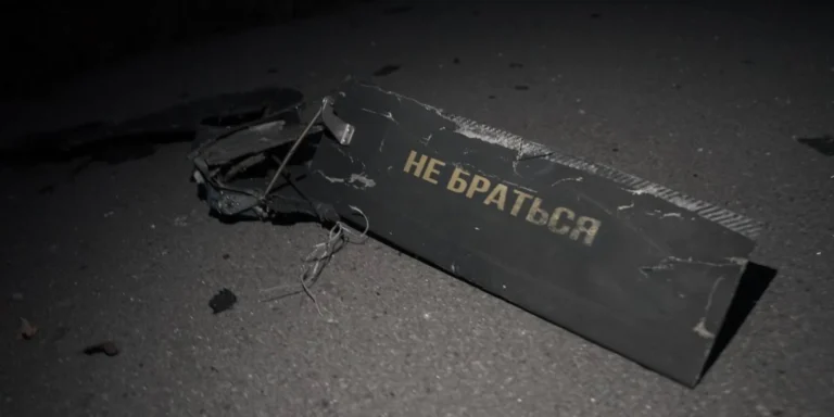 Російський дрон-камікадзе атакує українське місто, спричиняючи руйнування та жертви серед цивільних.