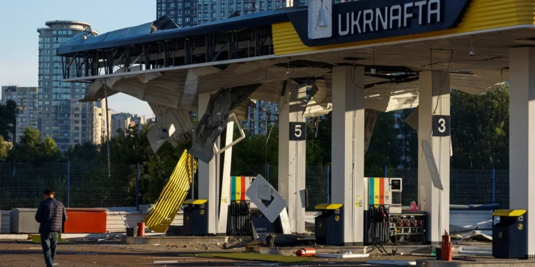Наслідки атаки ворожих дронів на Київ: палаюча автозаправна станція та задимлення над містом.
