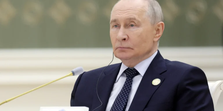Володимир Путін з цинічним виразом обличчя, натякаючи на його вимоги українських територій Донбасу для «мирних» переговорів, на тлі Кремля.